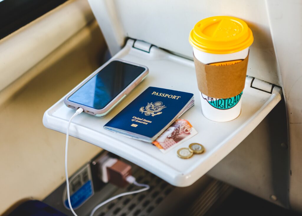 5 Benefits of Self-Catering Accommodation - close up of phone and passport on airplane